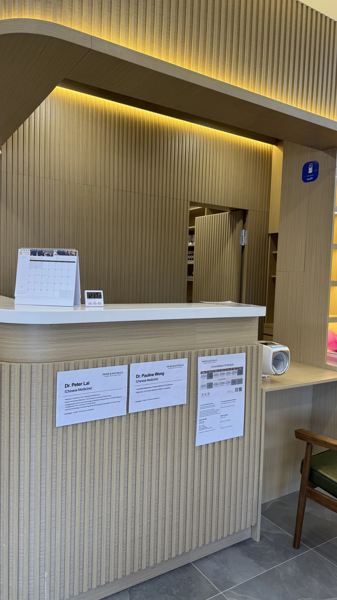 Framed practitioner credential cards displayed at the reception desk