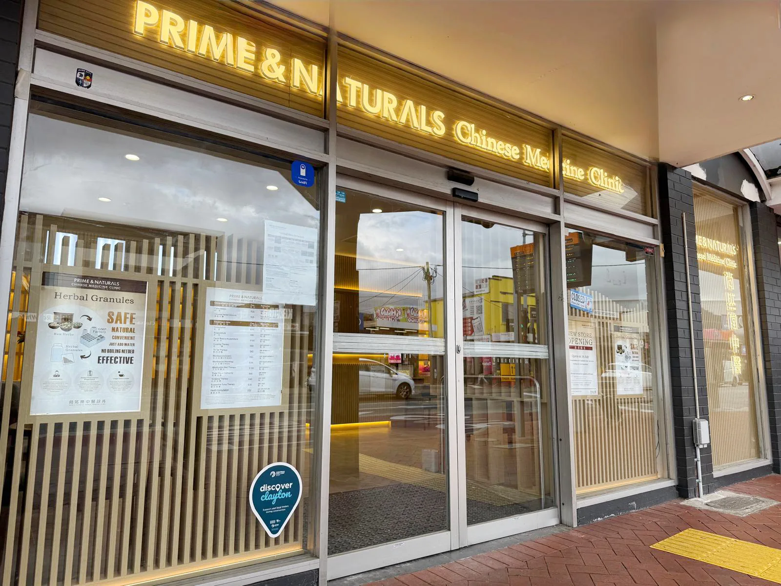 Prime & Naturals shopfront — glass entrance with herbal granules and price list in the window